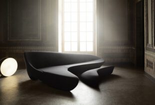 A black Moon System sofa by Zaha Hadid in a room with a shining light.