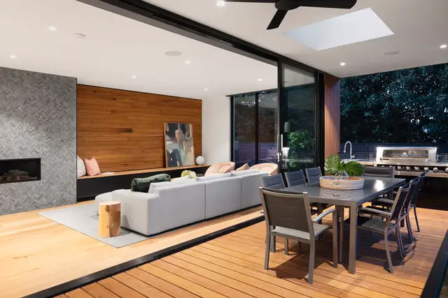 A modern living room and dining room with a large table and chairs and a white sofa.